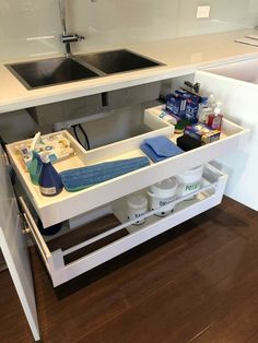 a sink and counter in a room with wood flooring next to a white wall