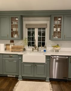 a kitchen with gray cabinets and white counter tops, silver dishwasher and stainless steel appliances