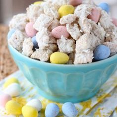 a blue bowl filled with rice krispy treats on top of a table next to napkins