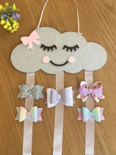 a wooden table topped with different types of hair clips and a cloud shaped paper cutout