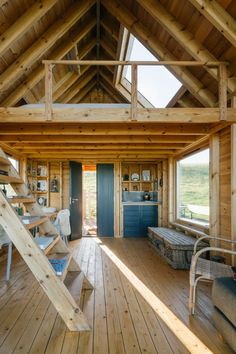 the inside of a log cabin with wood flooring and stairs leading up to it