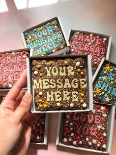 someone is holding up some decorated cookies in their box with the words your message here on them