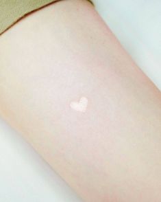 a small white heart on the back of a woman's thigh