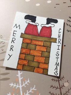 a christmas card with two red coats on top of a brick chimney and snowflakes in the background