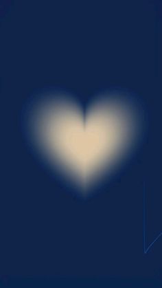 a blurry image of a heart in the dark blue sky with light coming from it