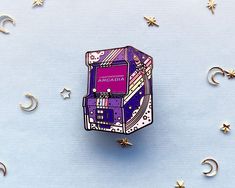 a purple and white box sitting on top of a blue surface surrounded by gold stars