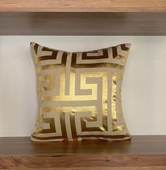 a gold pillow sitting on top of a wooden shelf