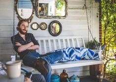 a man sitting on a porch swing with his arms crossed