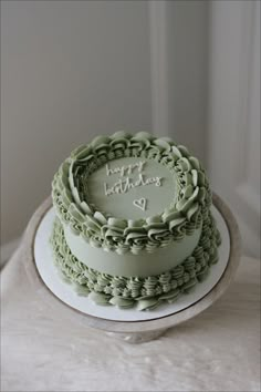 a birthday cake sitting on top of a white table next to a window with the words happy birthday written on it