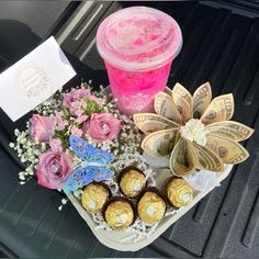 flowers and chocolates are sitting on the back seat of a car next to a pink drink