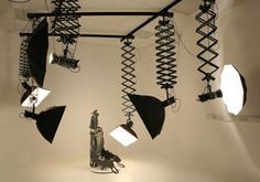 several lights are hanging from the ceiling in front of a camera and lighting equipment set up