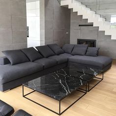 a living room with a couch, coffee table and stairs