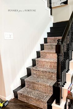 a set of stairs leading up to the second floor in a home with white walls and black railings