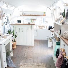 the inside of a camper with lots of storage space and plants on the shelves