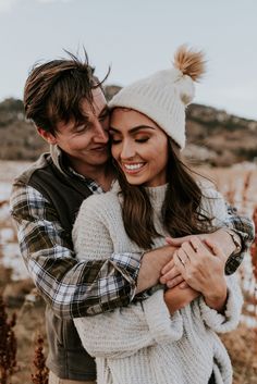 a man and woman hugging each other in the desert