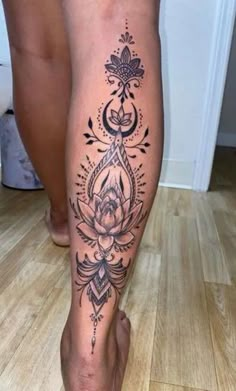 a woman's leg with a tattoo on it and a lotus flower in the center