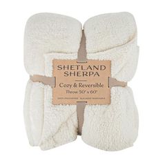 sherpa cozy and reversible throw blanket in white with brown label on front