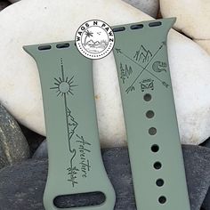 two green watch bands sitting next to each other on some rocks and stones with a seal stamp