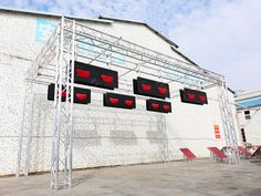 four stop lights are hanging on the side of a building that has been painted white and red