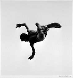 a man in the air on top of a surfboard with his arms out and feet up