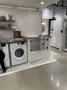 a man standing next to a washer and dryer in a room