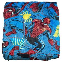 a blue spiderman blanket with yellow accents on it's sides and an image of the