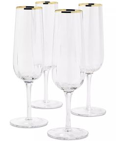 four clear wine glasses with gold rims