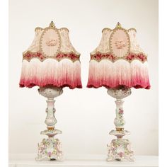 two lamps with pink and white shades on them