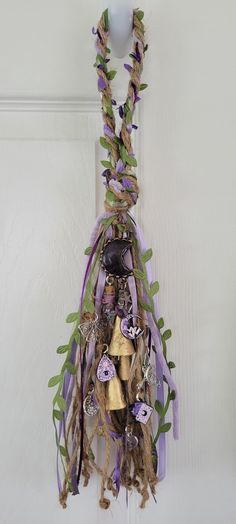 a bunch of items hanging from a hook on a door handle with purple ribbons around it