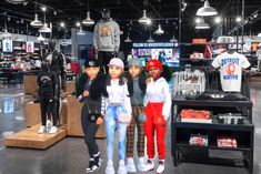 three girls are standing in front of some clothing on display at the store's showroom