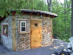 a small stone building sitting in the middle of a forest