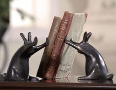 two bookends made to look like mice with books in their hands on a table