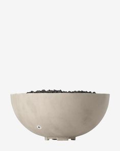 a white bowl filled with dirt on top of a table