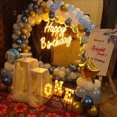 a birthday party with balloons and decorations on the floor, including a sign that says happy birthday