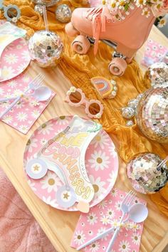 the table is set with pink and gold plates, confetti cups, and napkins