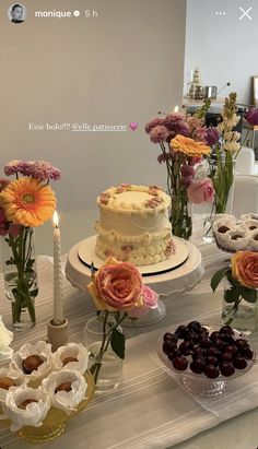 a table topped with lots of cakes and flowers