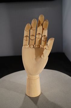 a wooden sculpture of a hand on top of a table