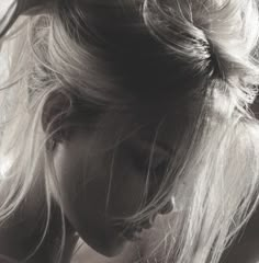 a black and white photo of a woman's head with her hair in a bun