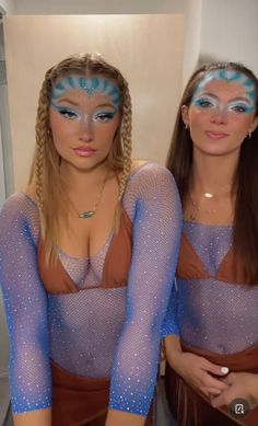 two women with blue and white face paint on their bodies, one is wearing a bodysuit