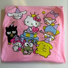 a pink hello kitty t - shirt with cartoon characters on it