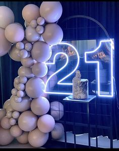 a table topped with balloons and a cake next to a neon sign that reads 12th