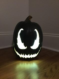 a carved pumpkin with glowing eyes on it's face is sitting on the floor