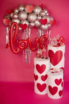 two rolls of toilet paper with hearts on them and some balloons in the shape of love