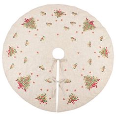 a white round table cloth with red and green flowers on the bottom, tied in a knot