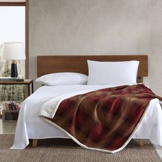 a bed with a plaid blanket on top of it