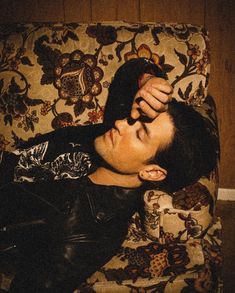 a young man laying on top of a couch