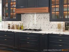 a kitchen with black cabinets and marble counter tops