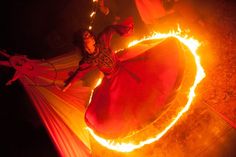 a woman is spinning fire around her body