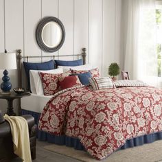 a bed with red and blue comforters in a room