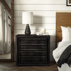 a bedroom with a bed, night stand and lamp on the nightstand next to it